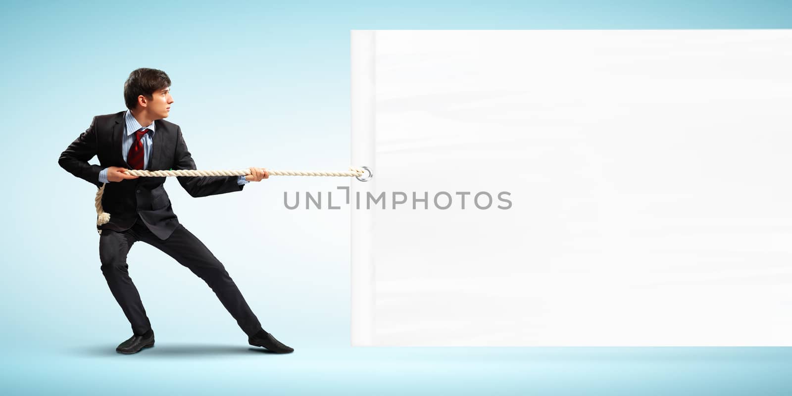 Image of businessman pulling blank banner. Place for text