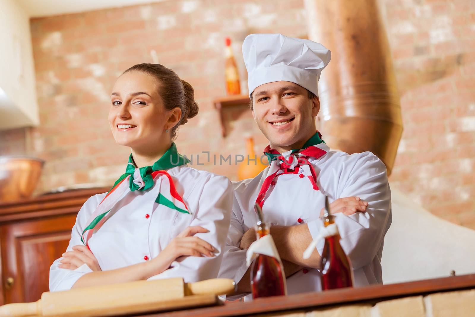 Portrait of two cooks with crossed arms looking at the camera