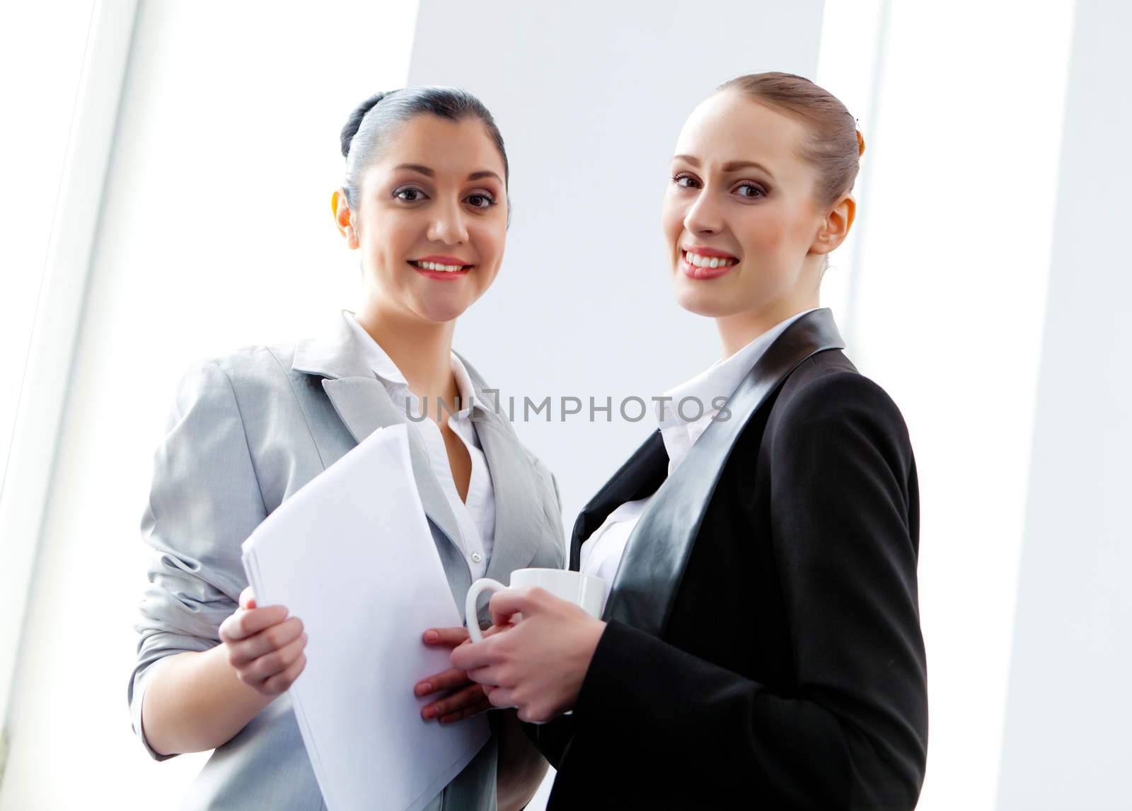 Image of two young pretty businesswomen smiling