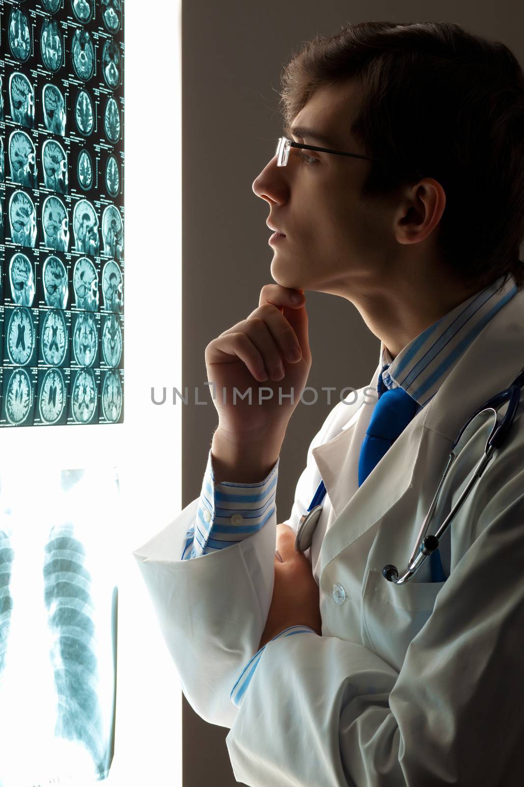 Man doctor looking at x-ray by sergey_nivens