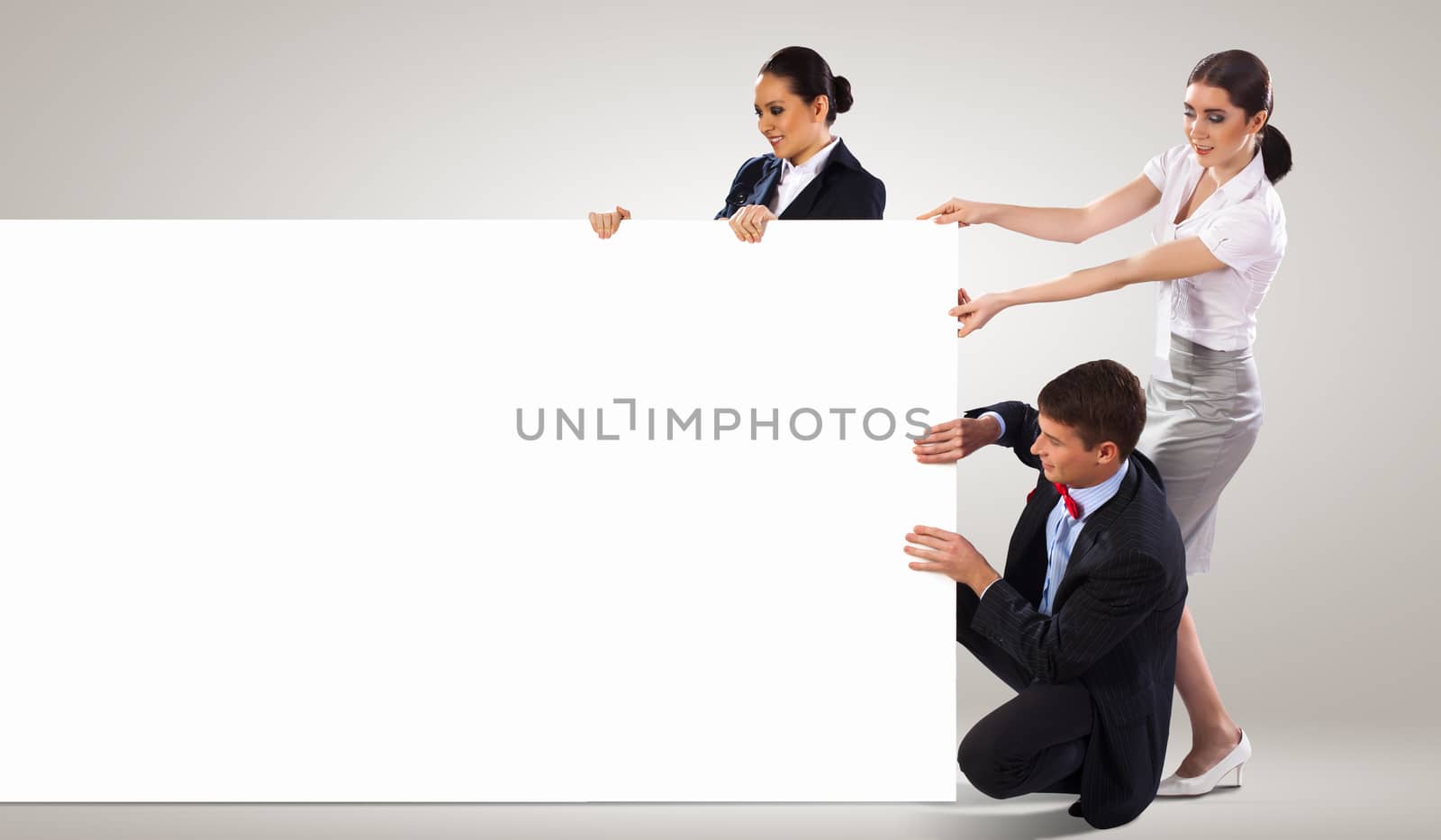 Image of three young people holding blank banner. Place for text