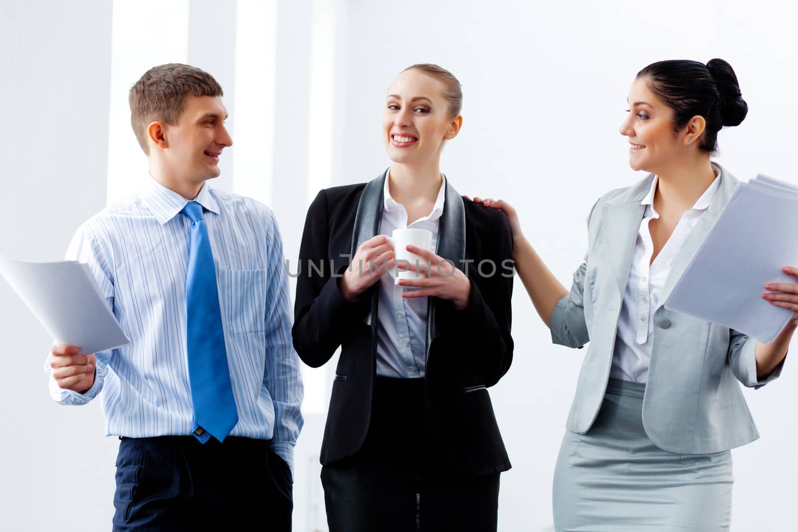 Image of three young businesspeople laughing joyfully
