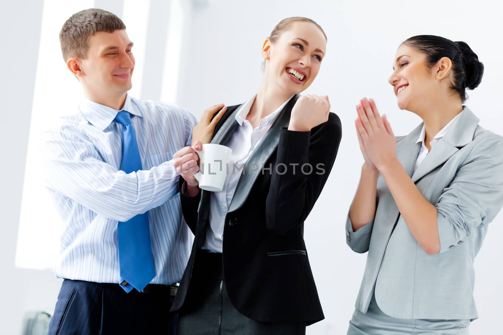 Image of three young businesspeople laughing joyfully