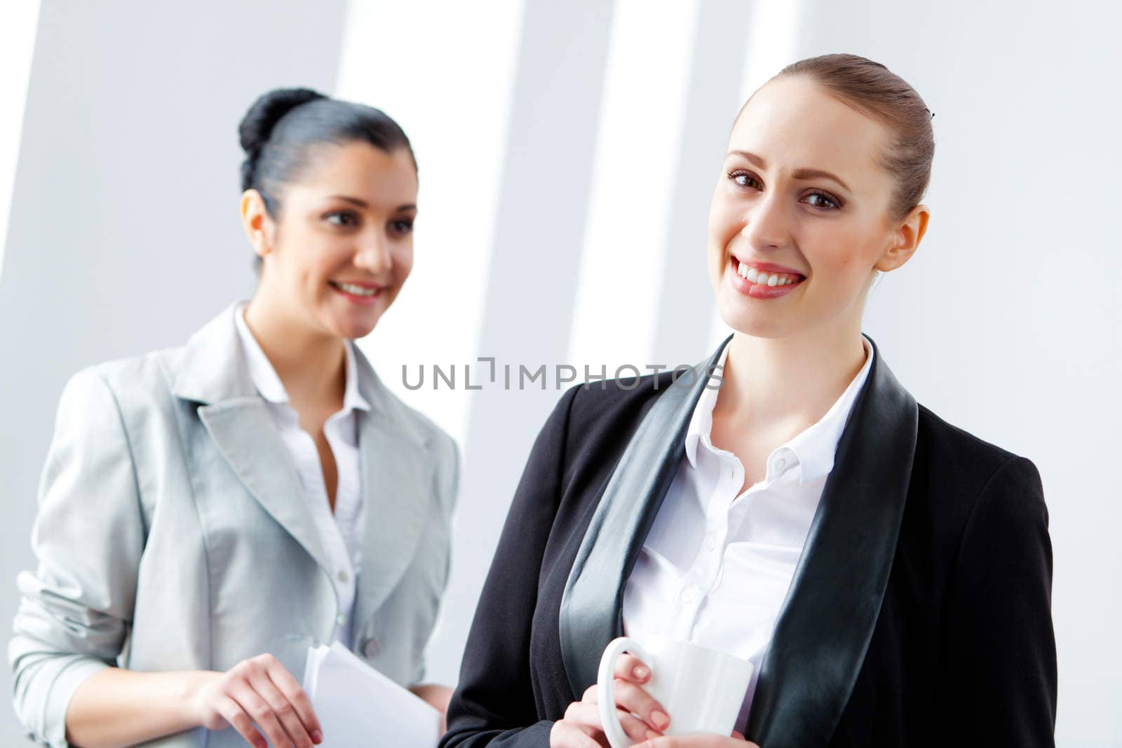 Two attractive business women smiling by sergey_nivens