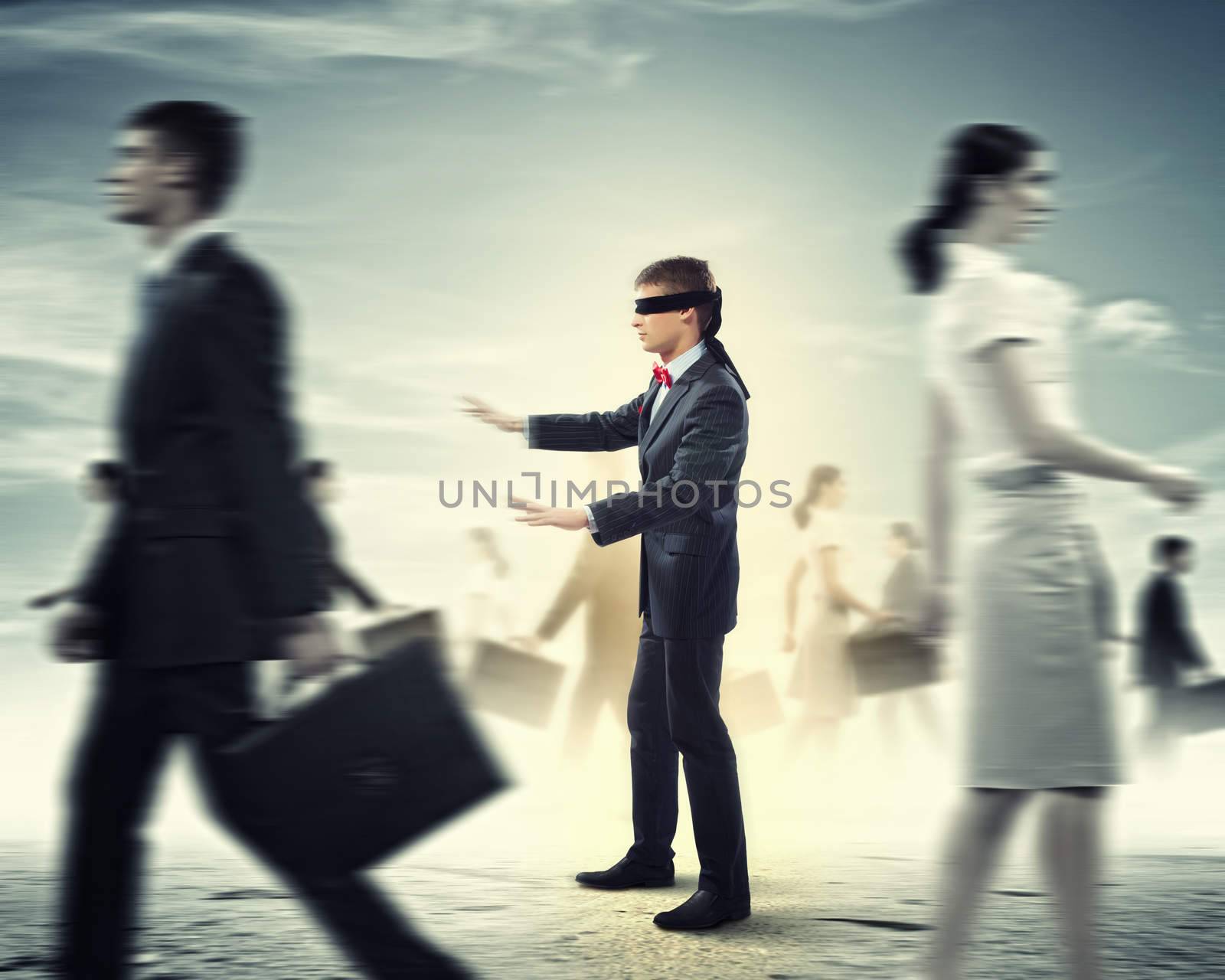 Image of businessman in blindfold walking among group of people