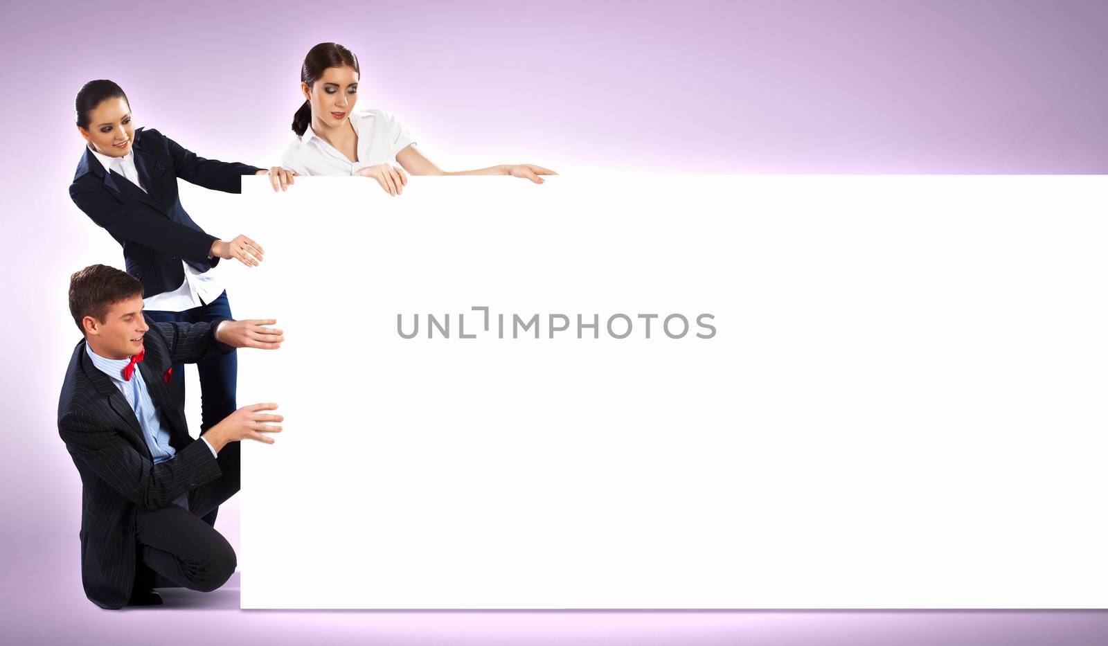 Image of three young people holding blank banner against purple background. Place for text