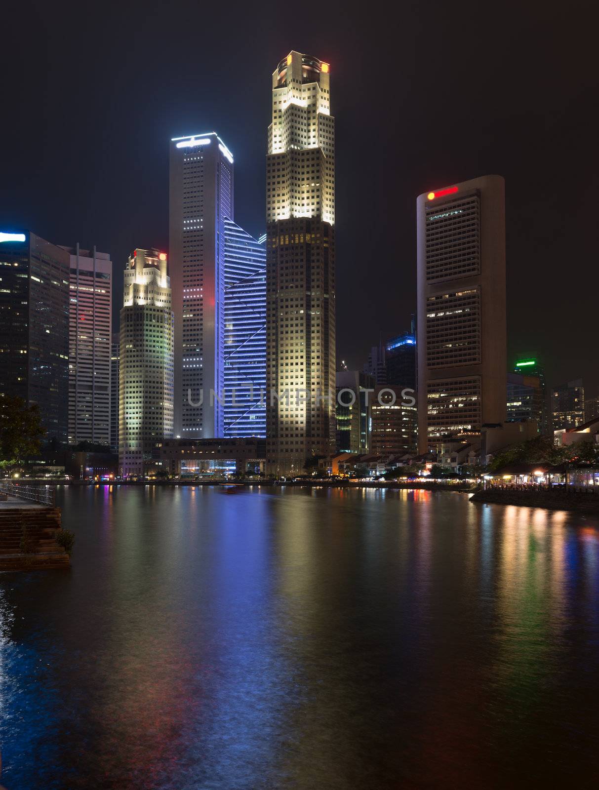 Singapore quay with tall illuminated skyscrapers in the central business district at night
