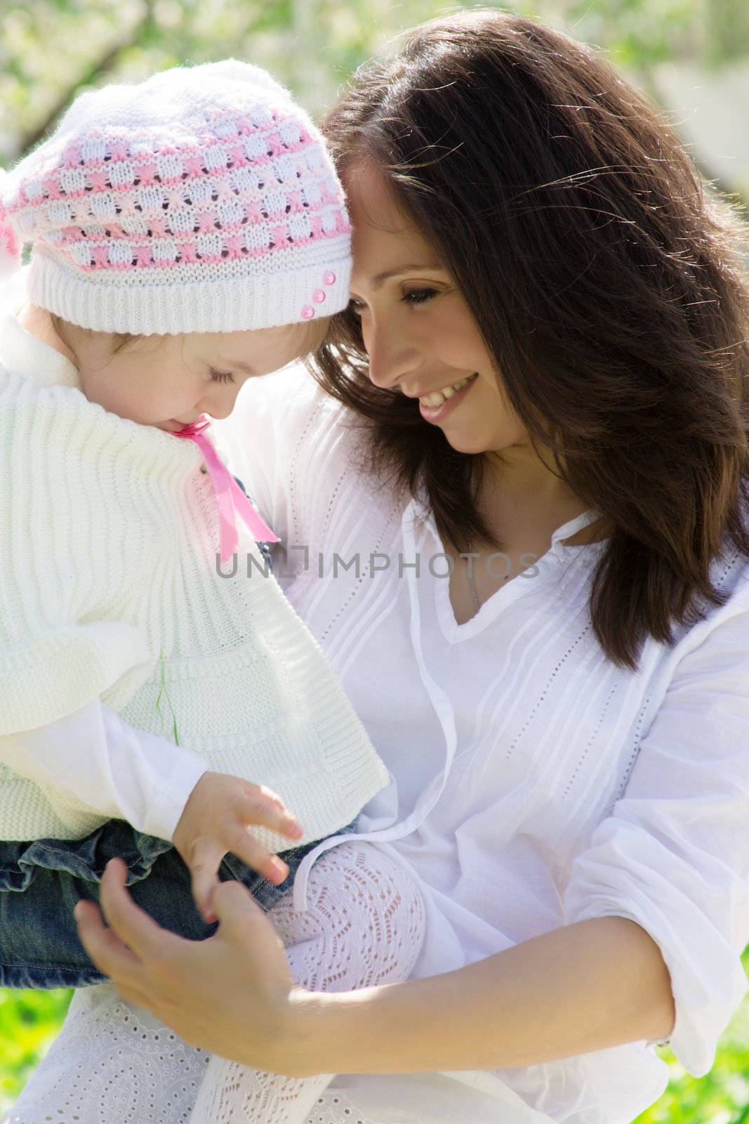 Happy mother and baby girl in spring garden