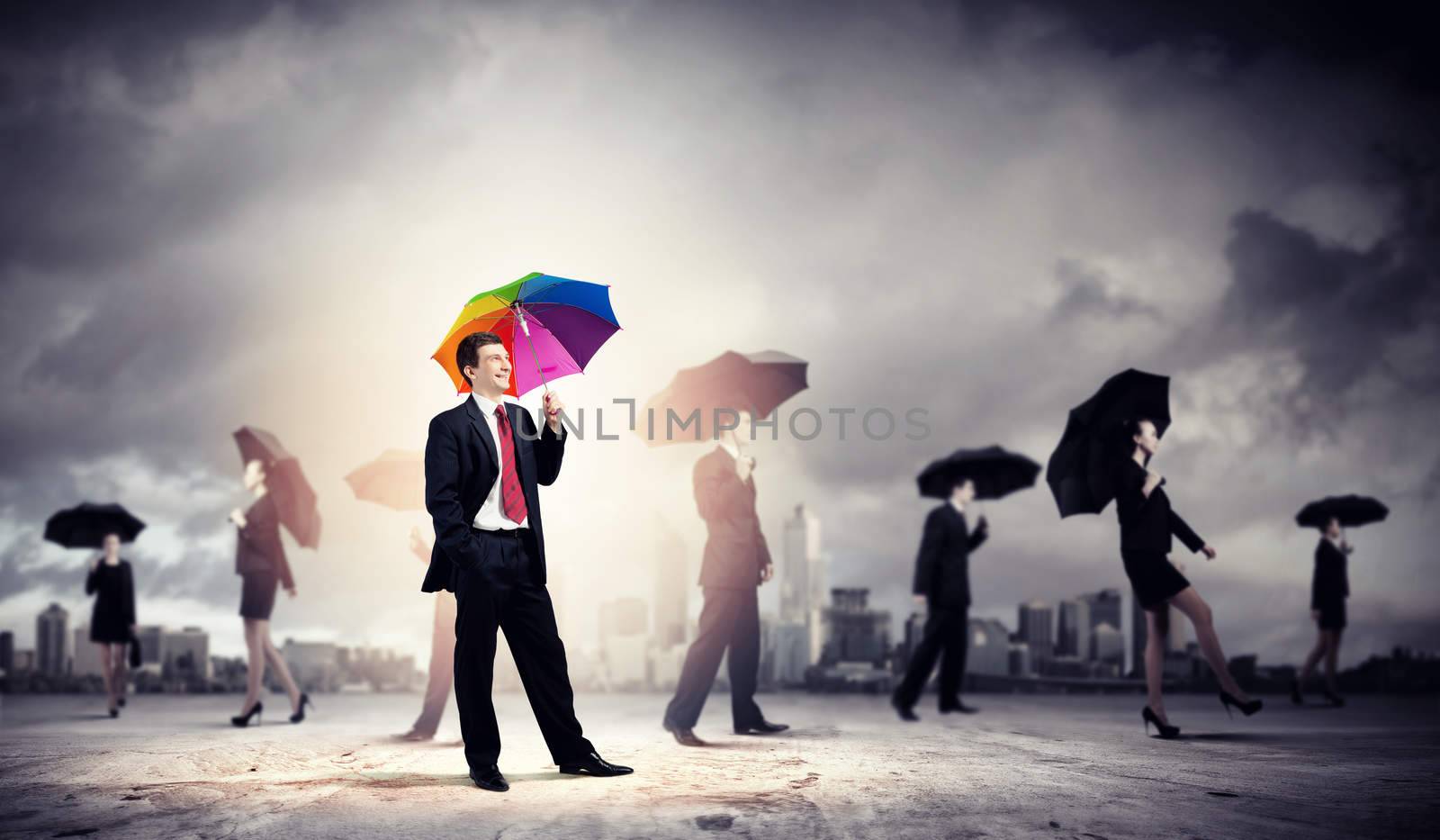 Image of pretty businessman with umbrella walking in crowd of people