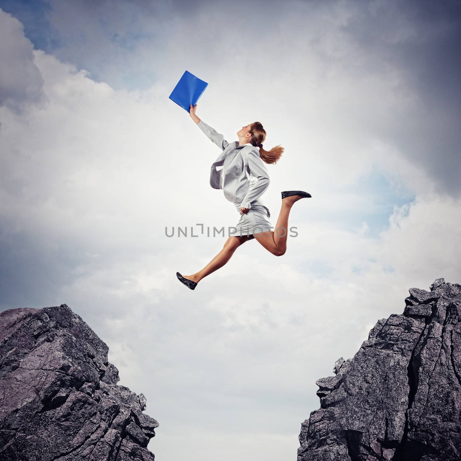 Image of young businesswoman jumping over gap