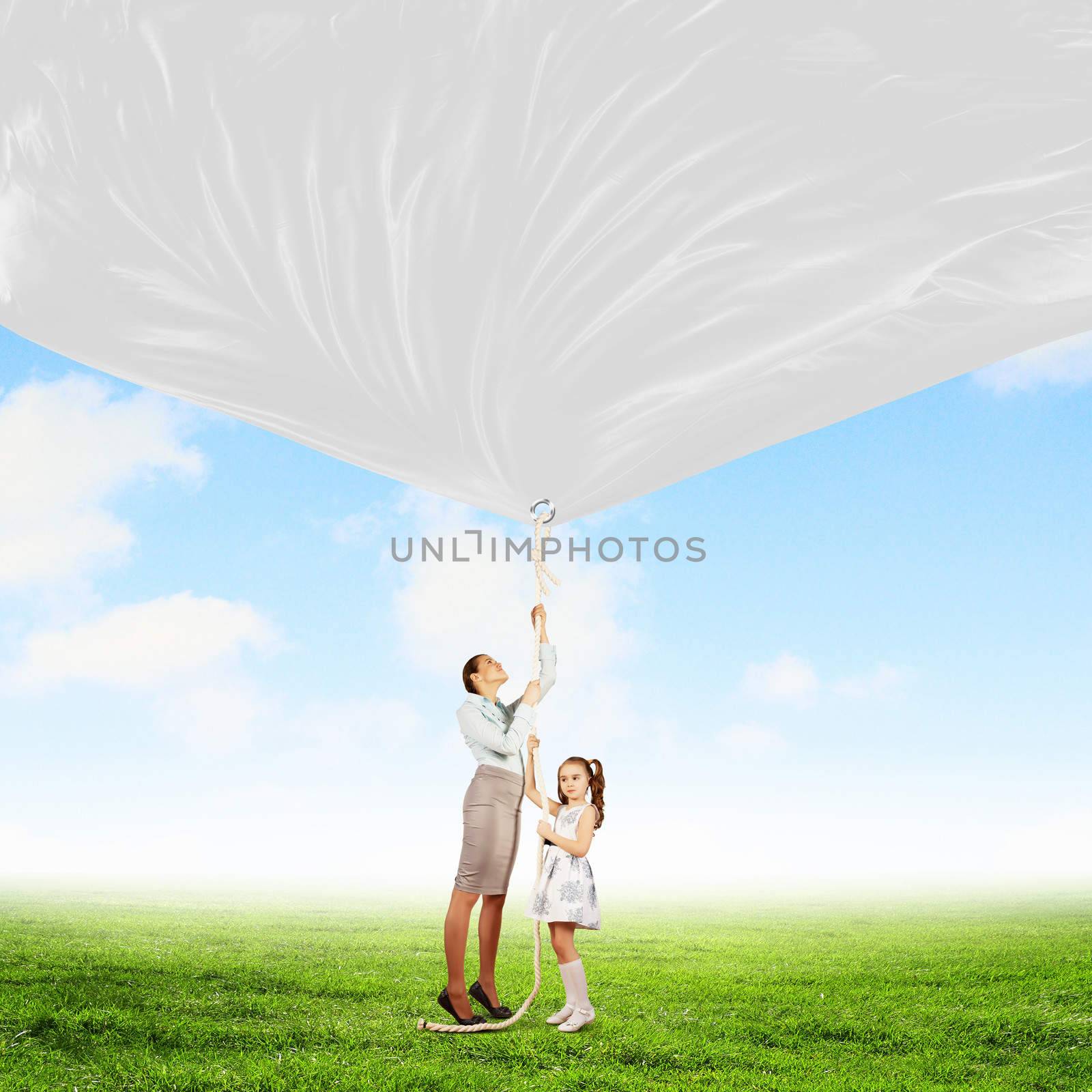 Image of young happy family pulling blank banner