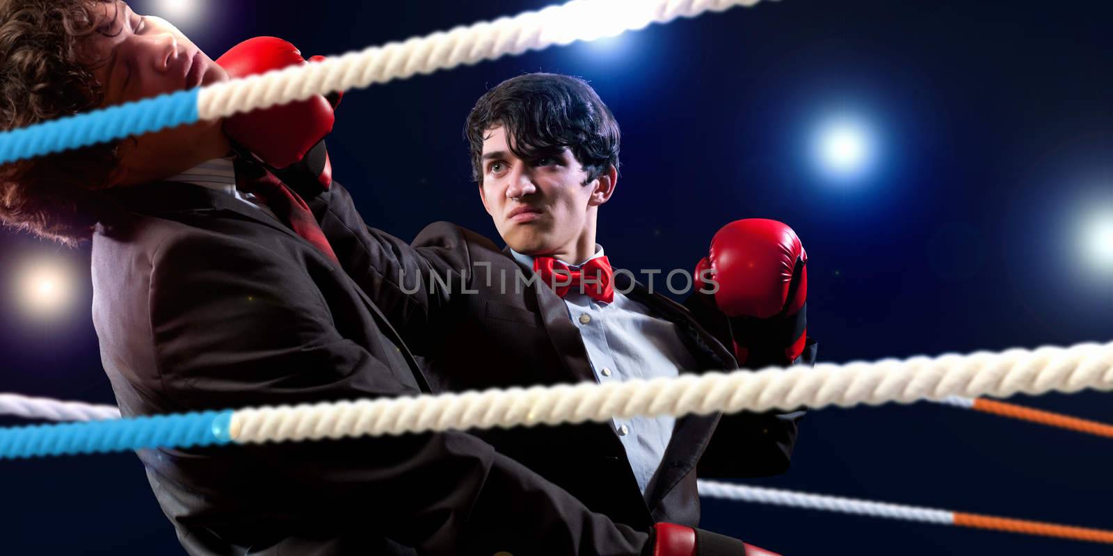 Two young businessman boxing againts dark background . conceptual collage