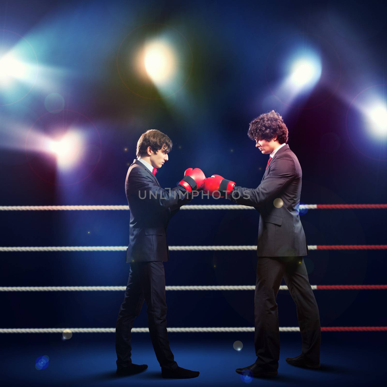 Two young businessman boxing againts dark background . conceptual collage