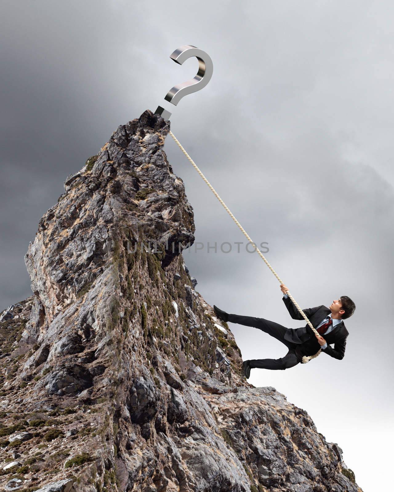 businessman climbing mountain with question sigh on top