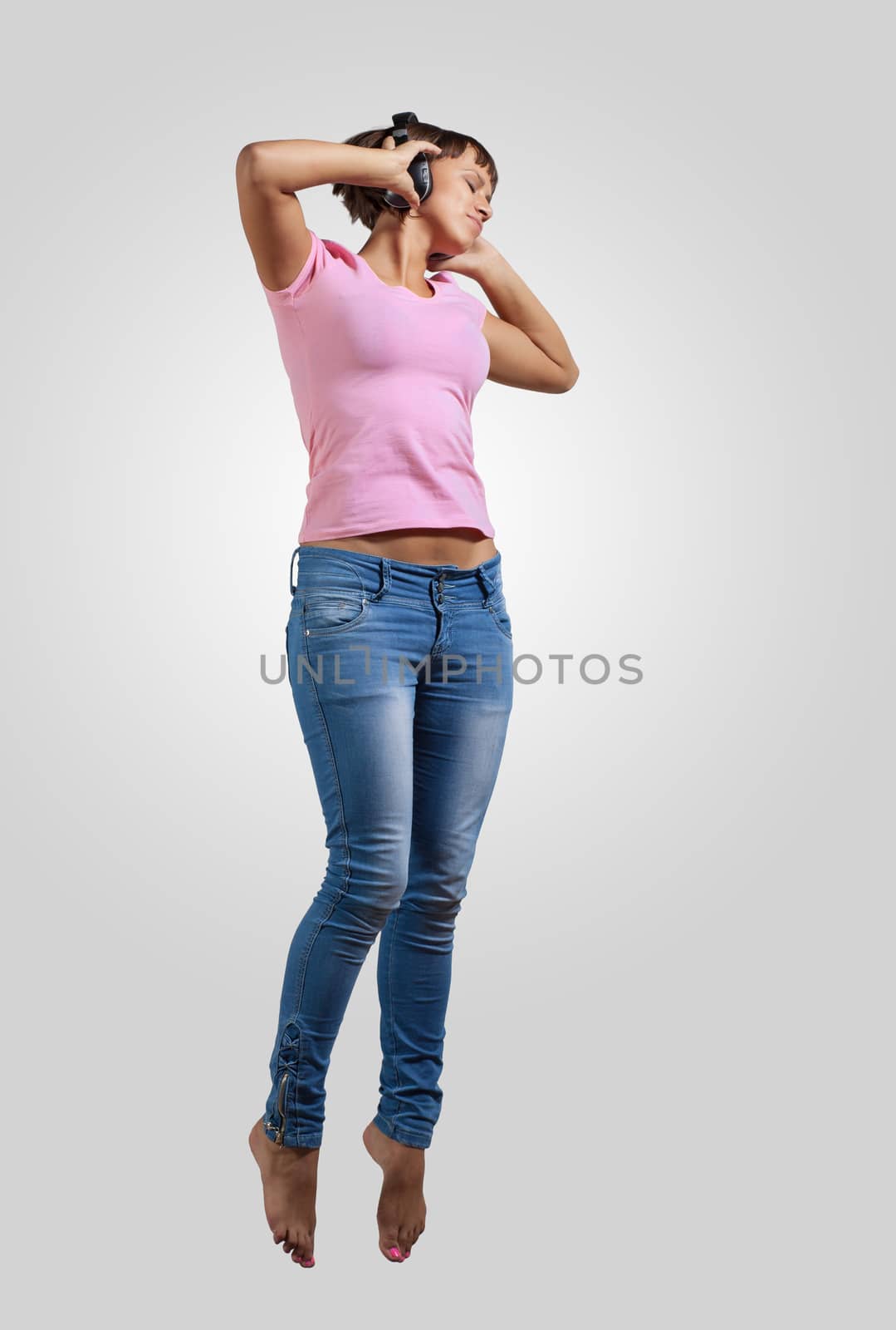 pretty modern slim hip-hop style woman jumping dancing on a colour background