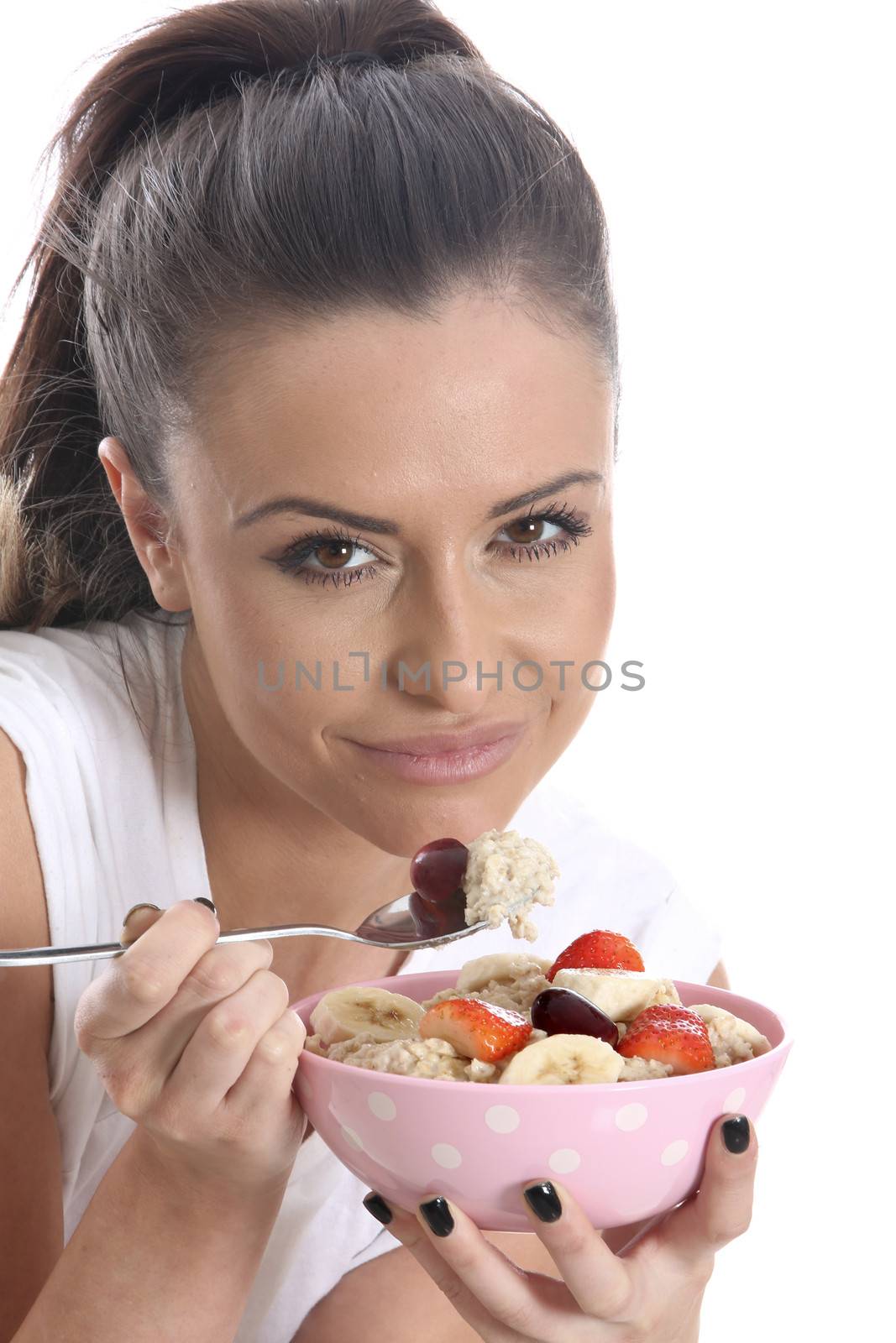 Model Released. Young Woman Eating Porridge and Fresh Fruit