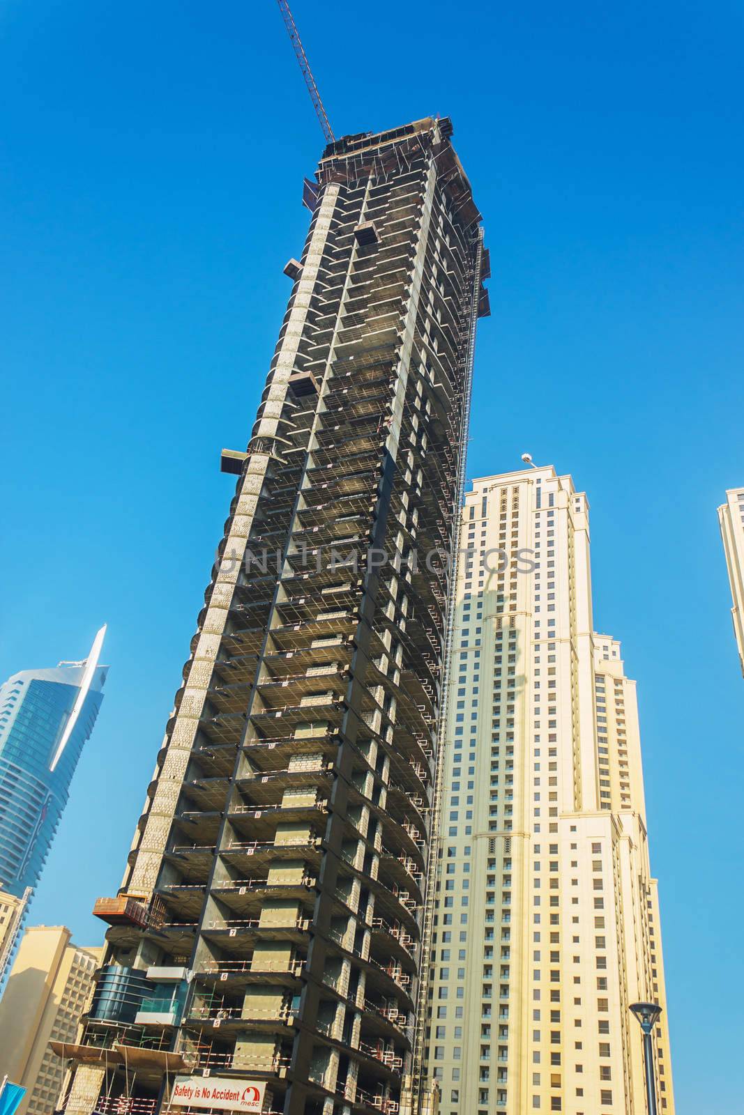 DUBAI, UAE - NOVEMBER 13: High rise buildings and streets nov 13. 2012  in Dubai, UAE. Skyscraper under construction in foreground. Dubai was the fastest developing city in the world between 2002 and 2008.