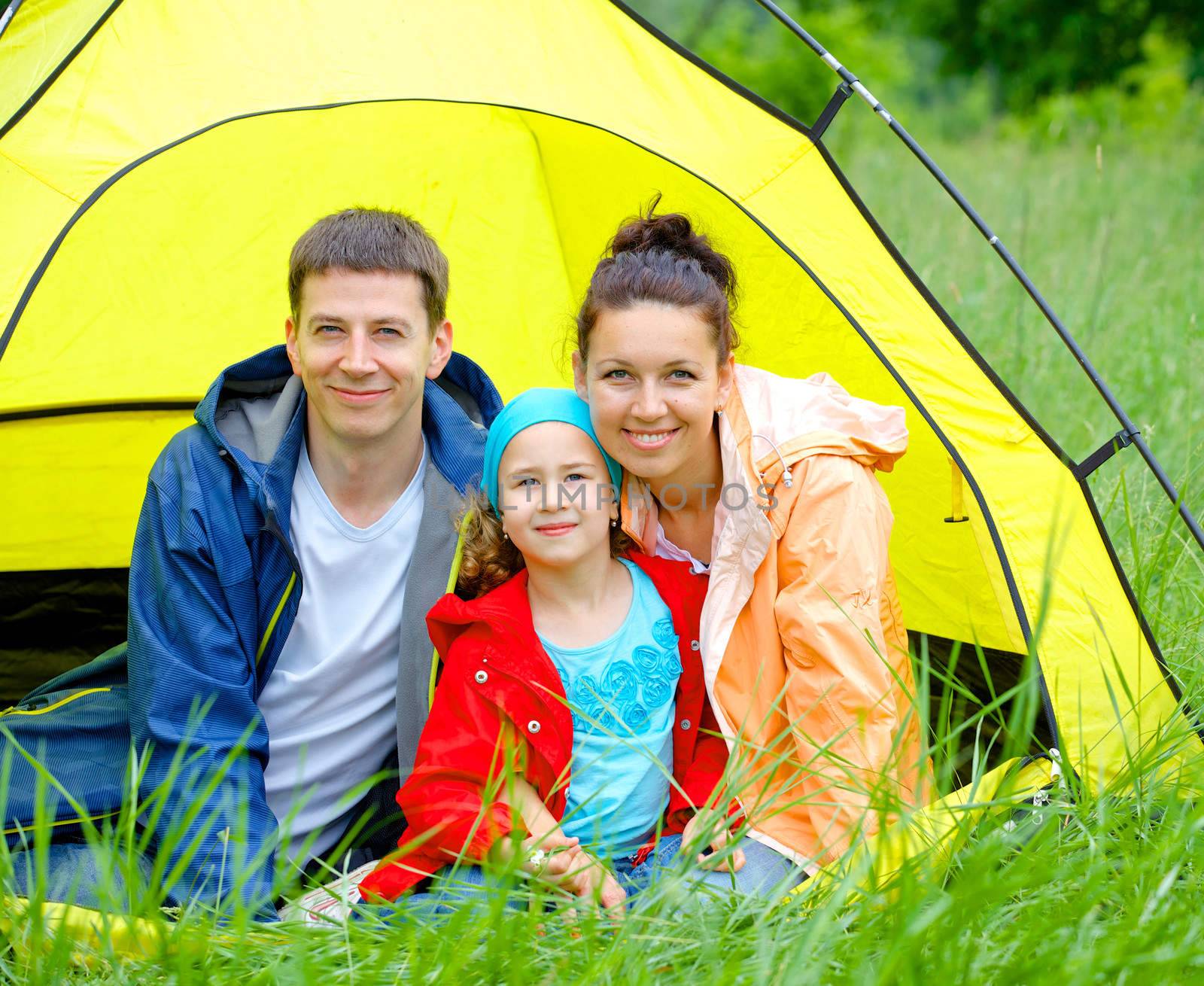 Summer vacation. Family of three in tent in camping on the nature.