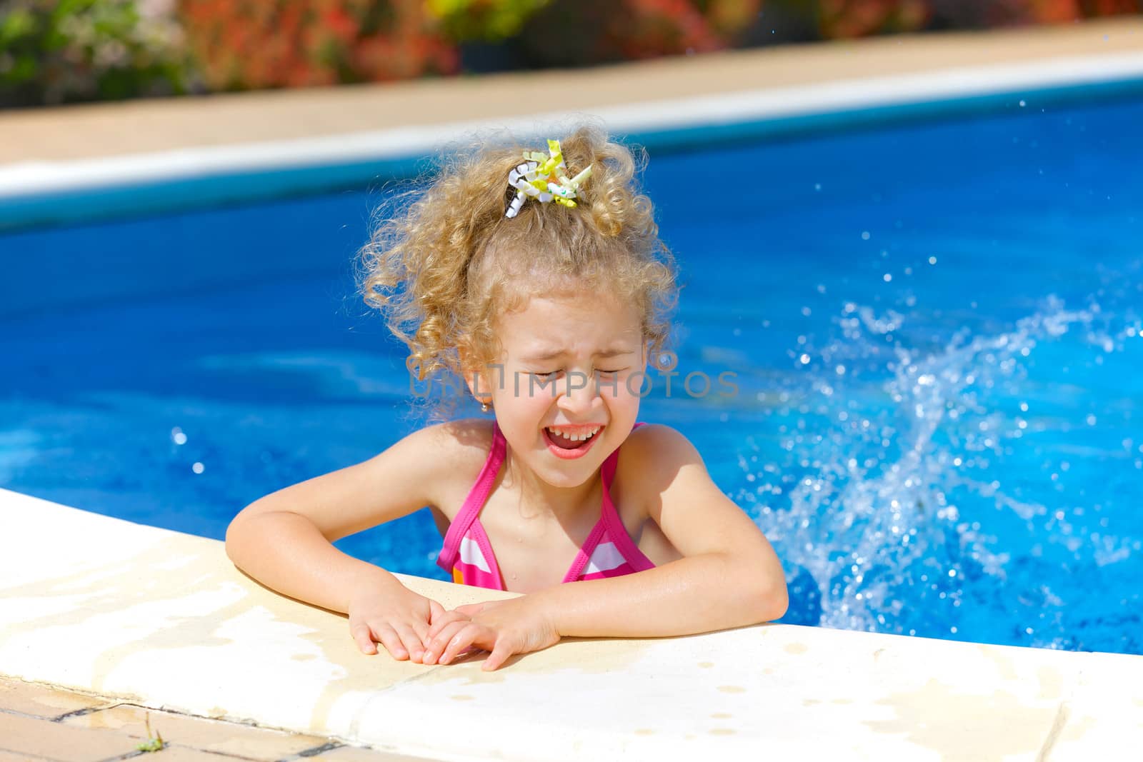 Pretty little girl in swimming pool outdoors