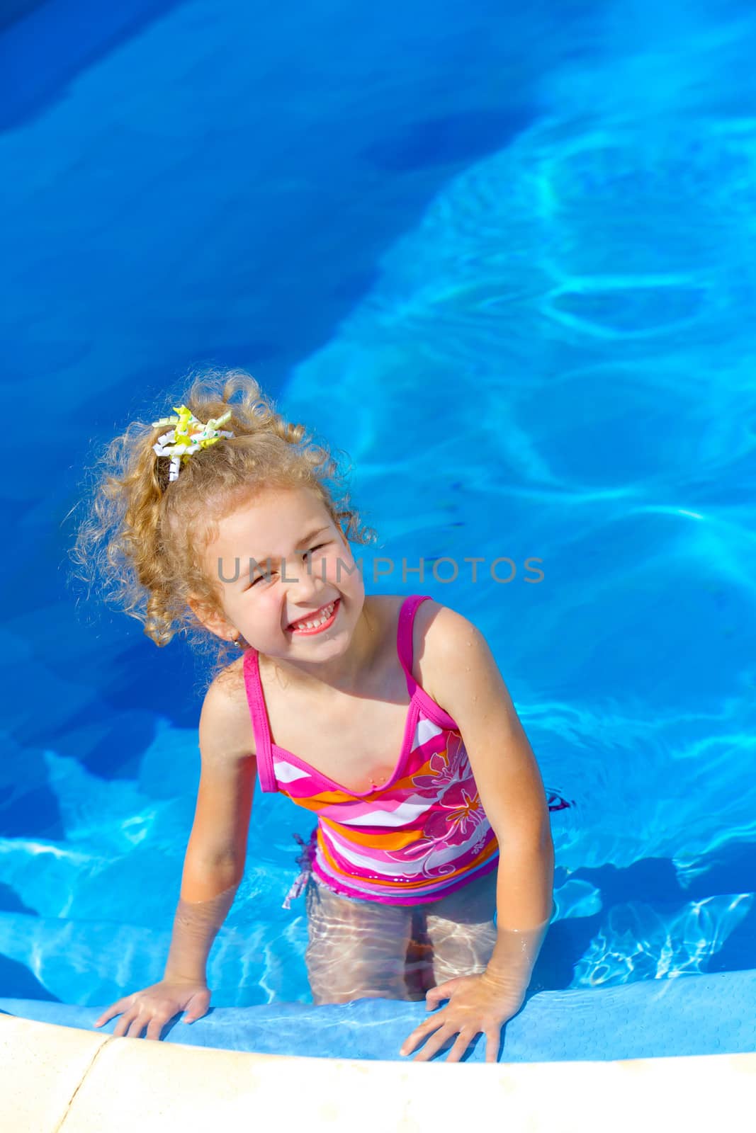 Pretty little girl in swimming pool outdoors