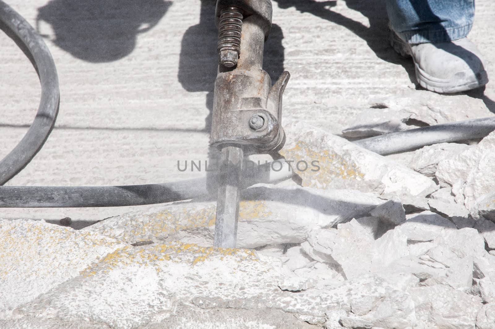 working man breaking the ground with a machine