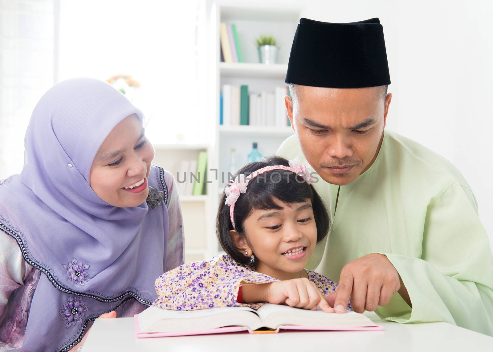 Malay Muslim parents teaching child by szefei