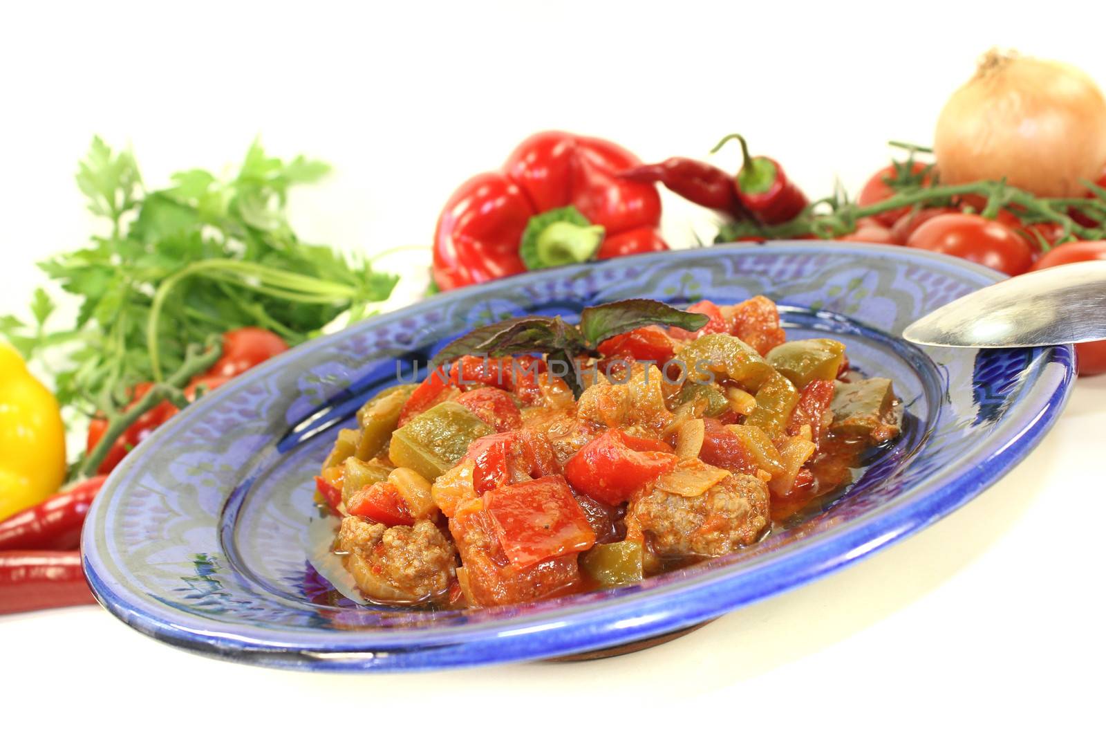 Tunisian tagine Kefta with tomatoes, peppers and ground beef on a light background