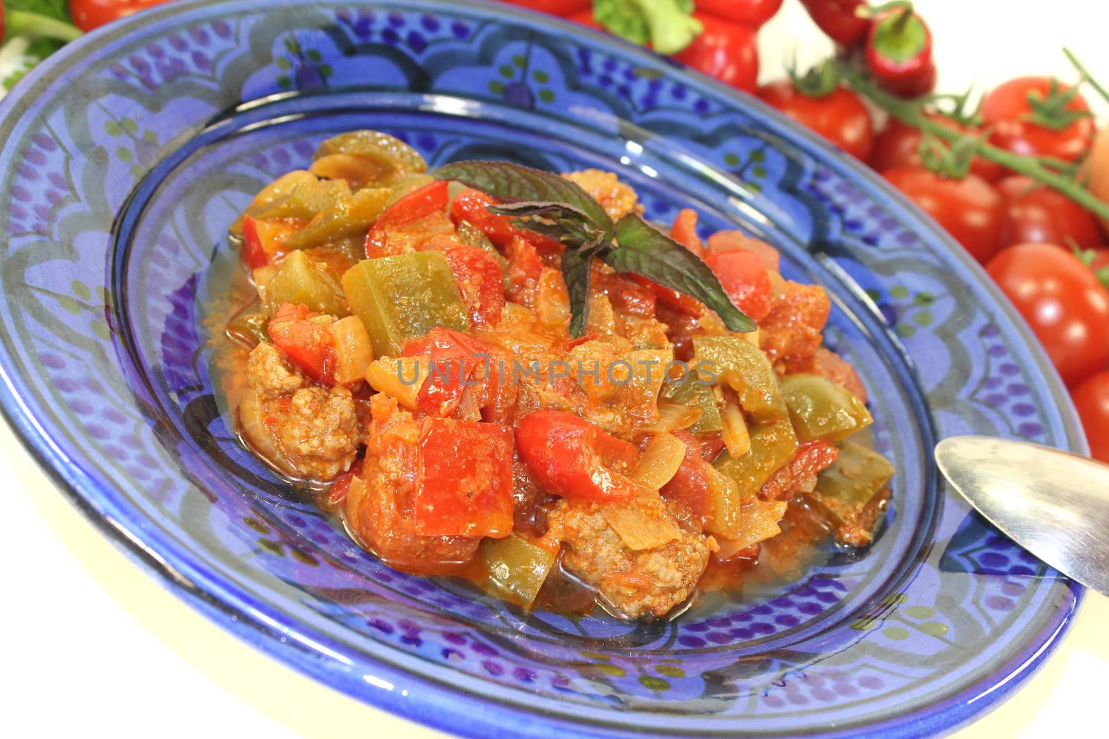 freshly cooked Tagine Kefta with tomatoes, peppers and ground beef on a light background