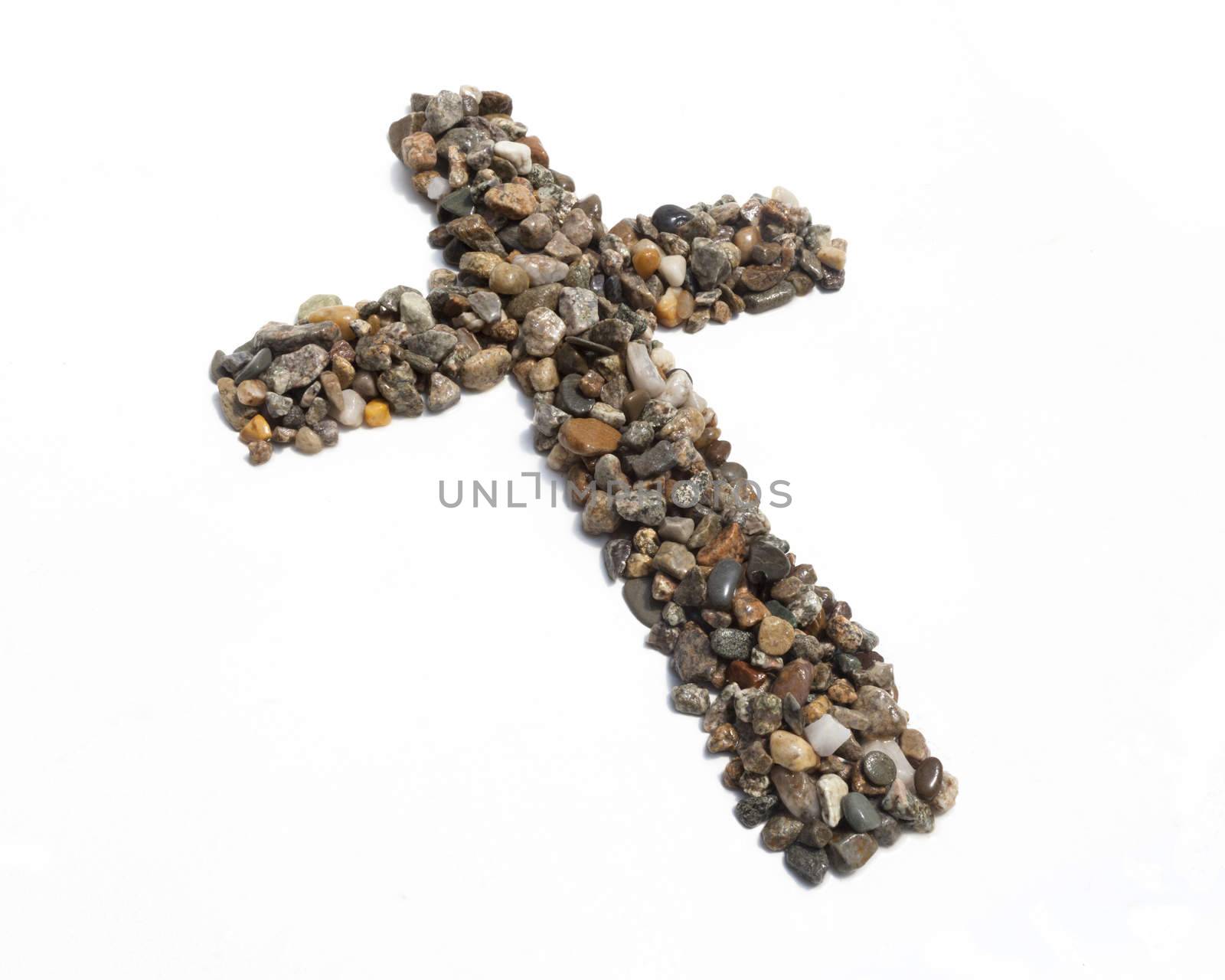 A cross made of pebbles against a white background.