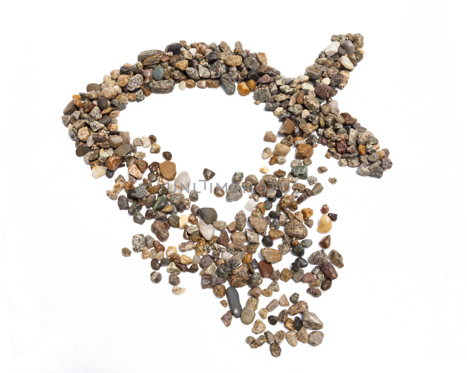 An ichthus made of stones against a white background.