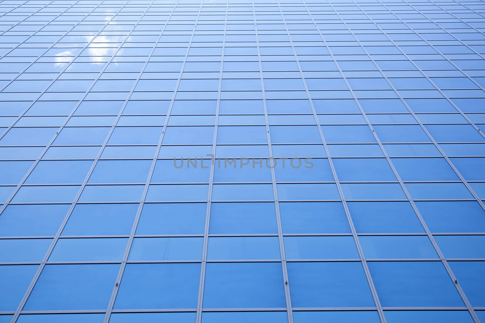 blue sky and one cloud reflected in facade of office building in Rotterdam