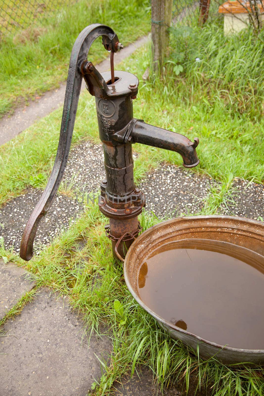 old rusty cast iron water pump in garden
