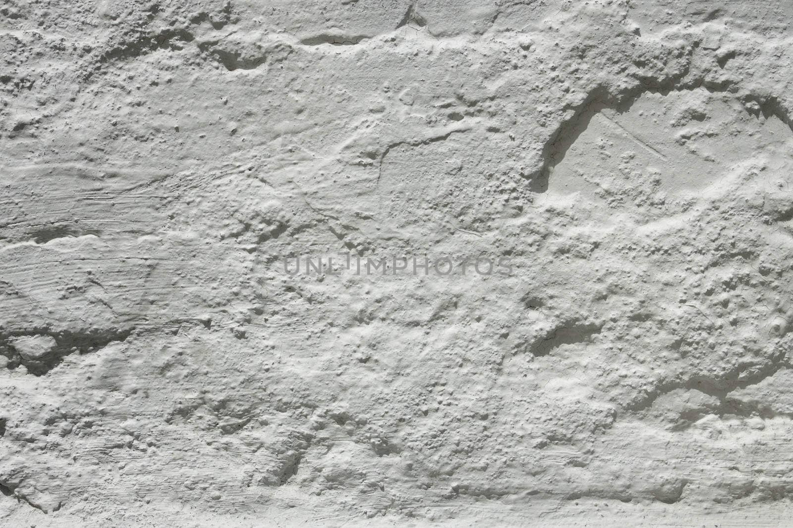 Fragment of an old wall painted with white fresh lime in a sunny day