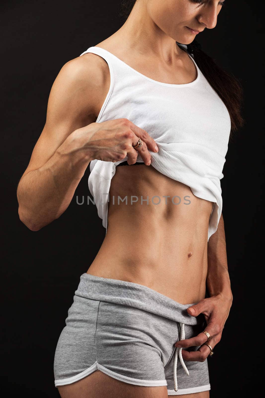 Close up view of young fitness woman over black