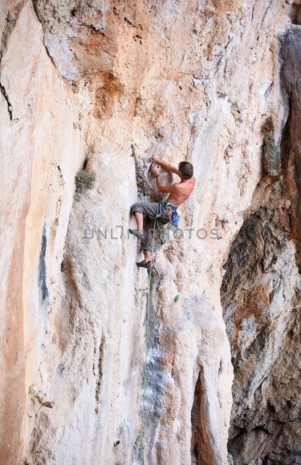 Young male rock climber on a cliff
