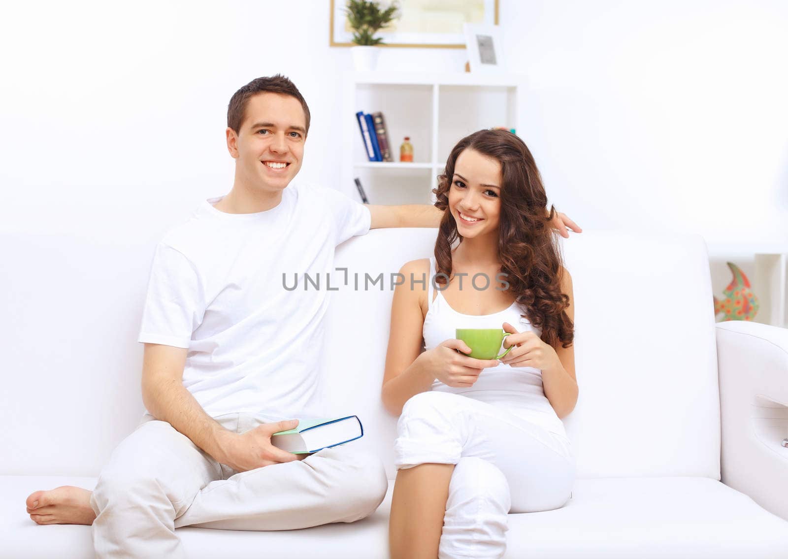 Young happy couple at hone together sitting and talking