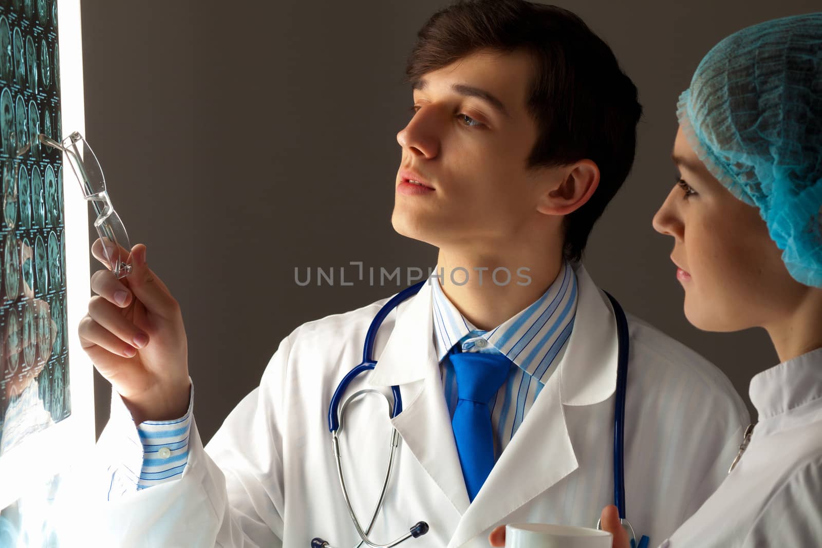 Image of two young two doctors discussing x-ray results
