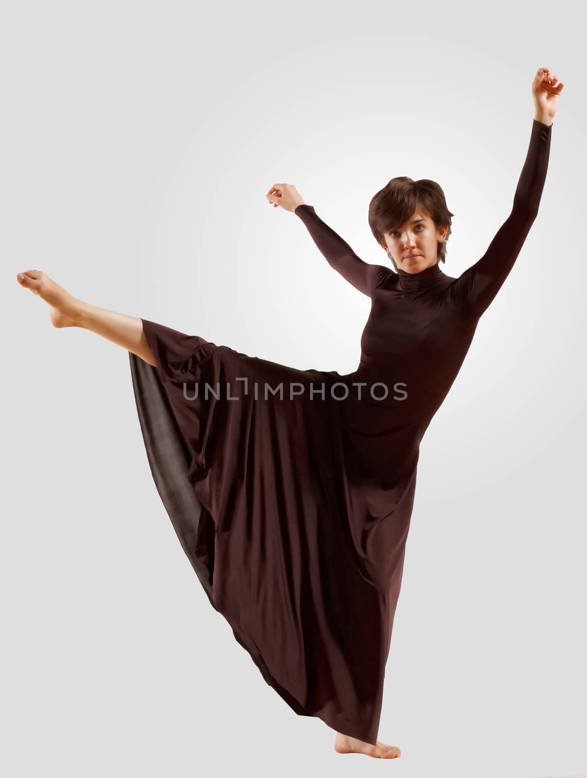 Girl dancing in a dark dress with a gray background. isolate