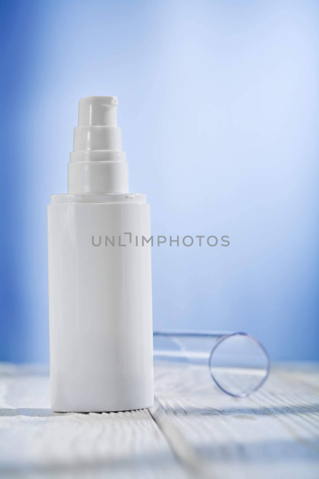 single skincare sprayer on white wooden table