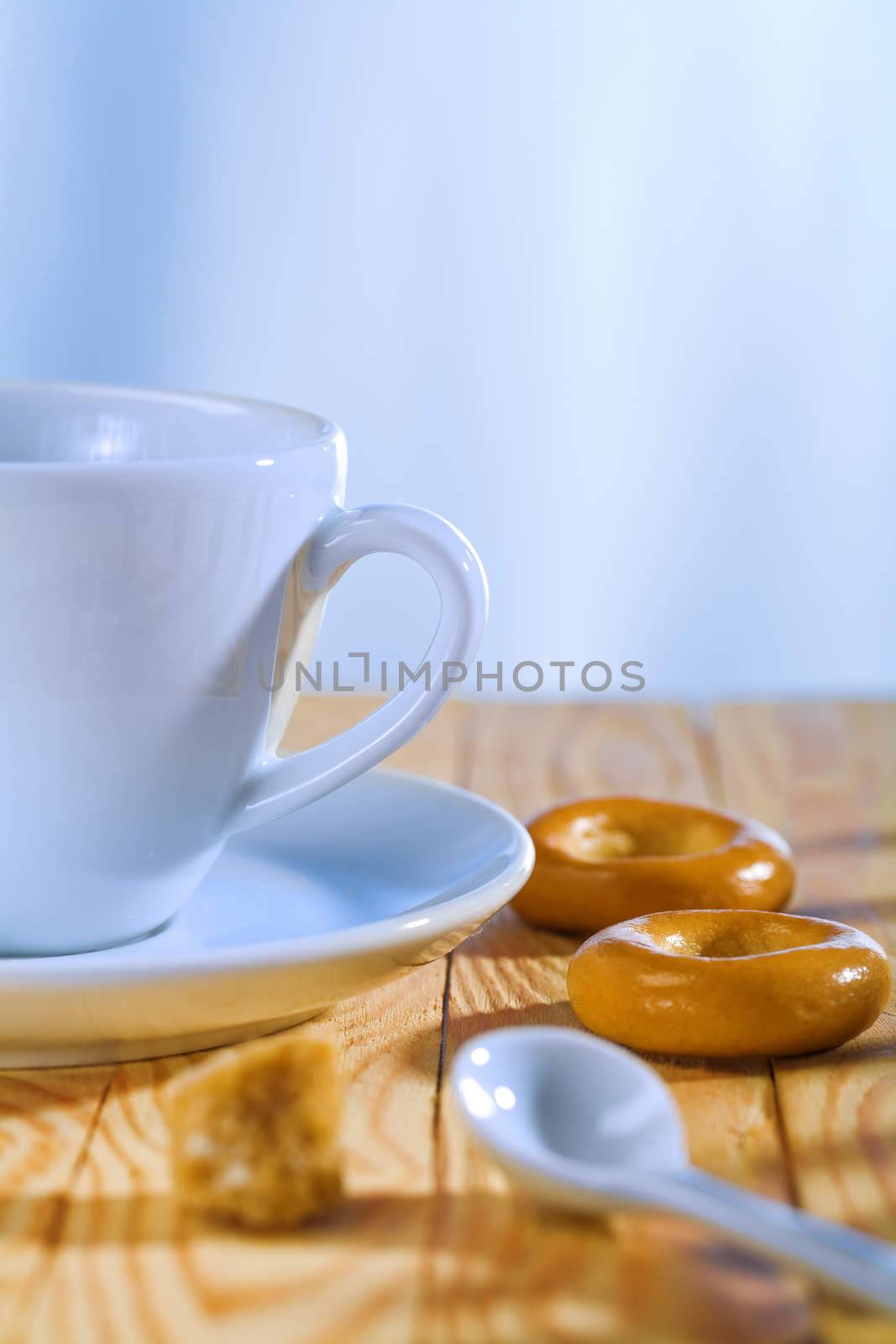 white cup with spoon and bread tor on in the room