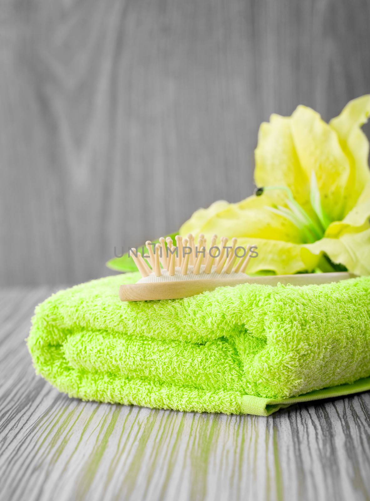 yellow flower on green towel with hairbrush