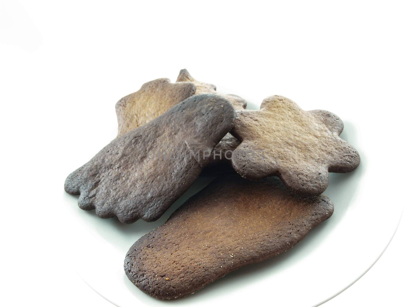 Burned gingerbread cookies on white plate towards white background