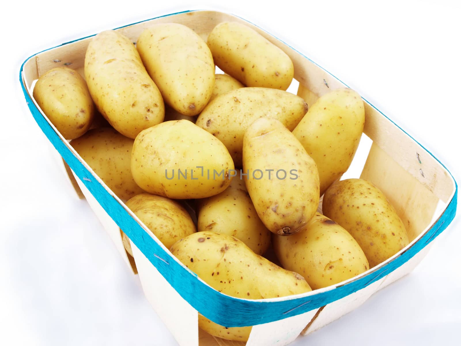 Fresh potatoes with shell, in a basket towards white background