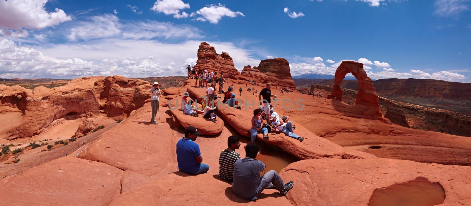 Tourists, Delicate Arch on background, Arches National Park, Utah, USA