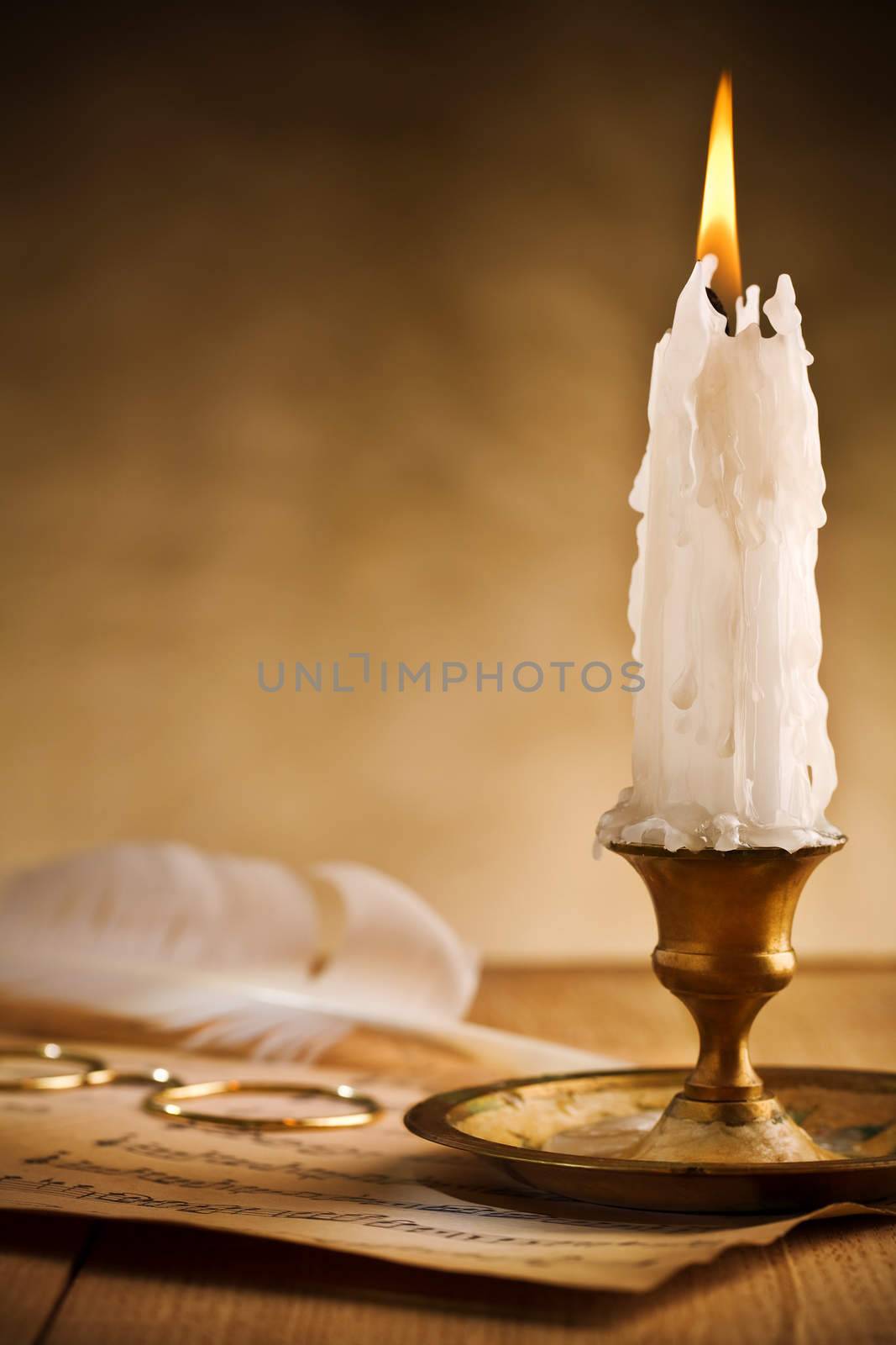 Antique brass candlestick with burning candle