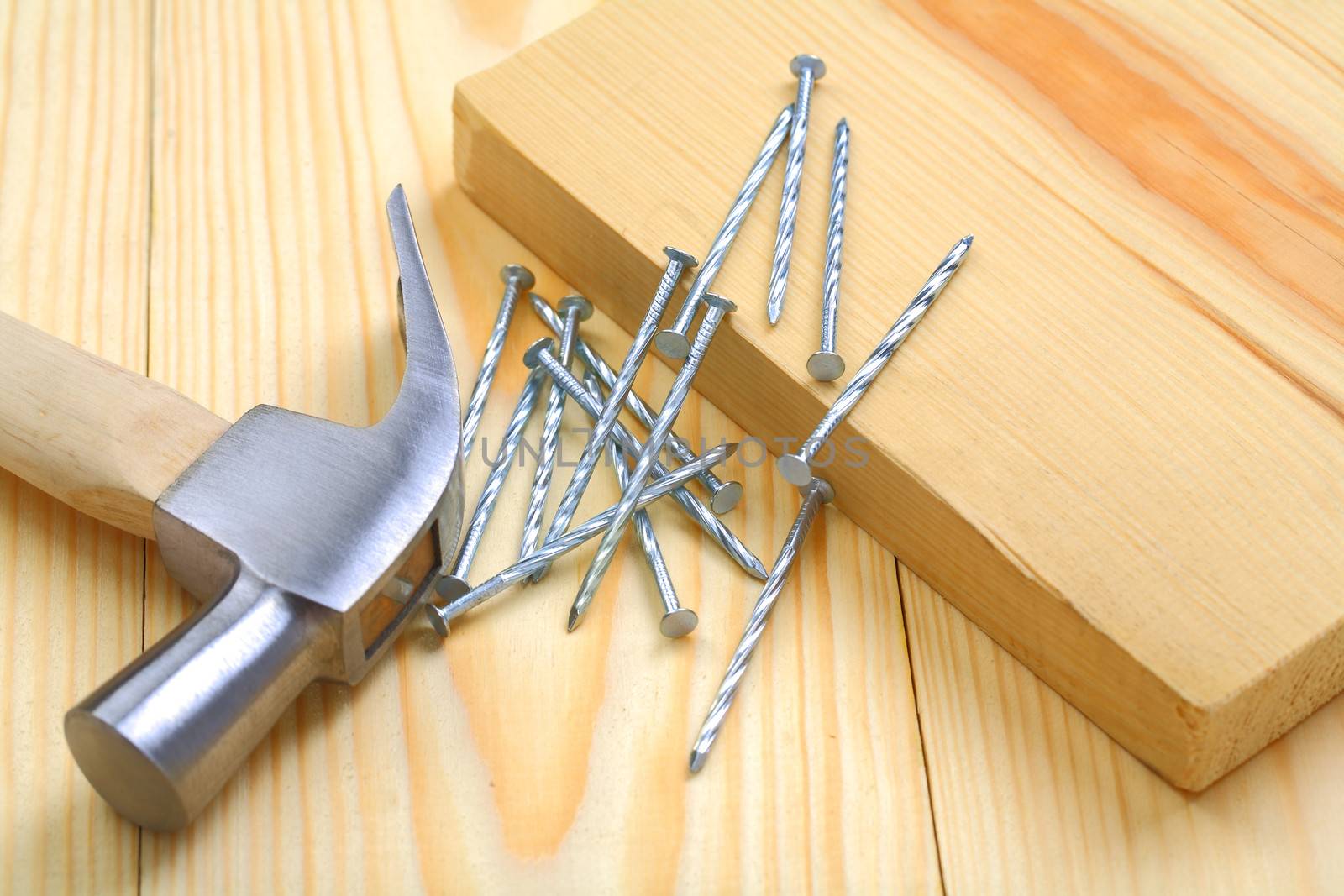 claw hammer with nails and timber on table