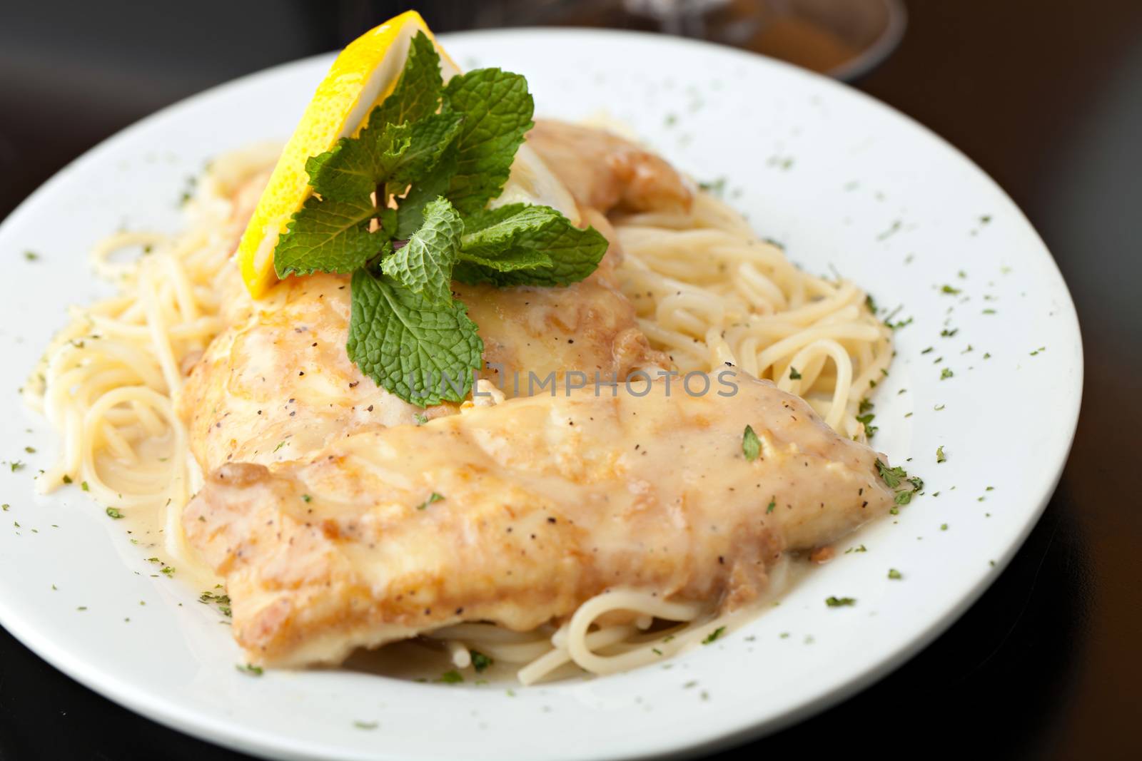 Chicken francaise or francese plated with pasta on a white dish.