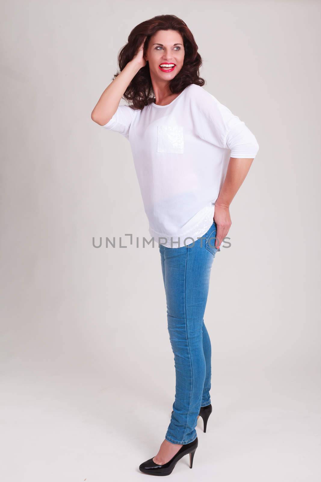 laughing senior model in fashionable jeans with a white blouse