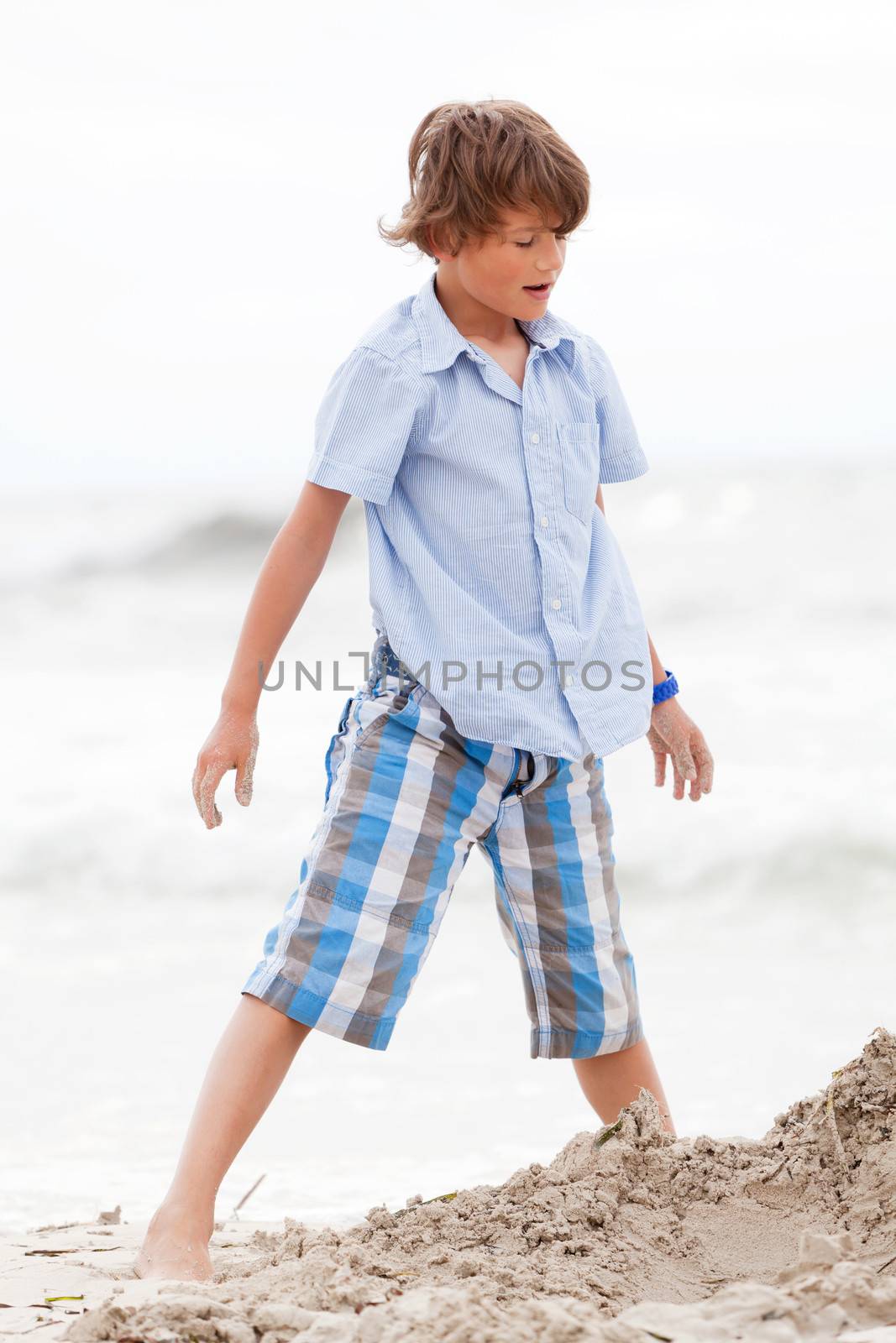 little boy playing in sand on the beach summer holiday fun happiness