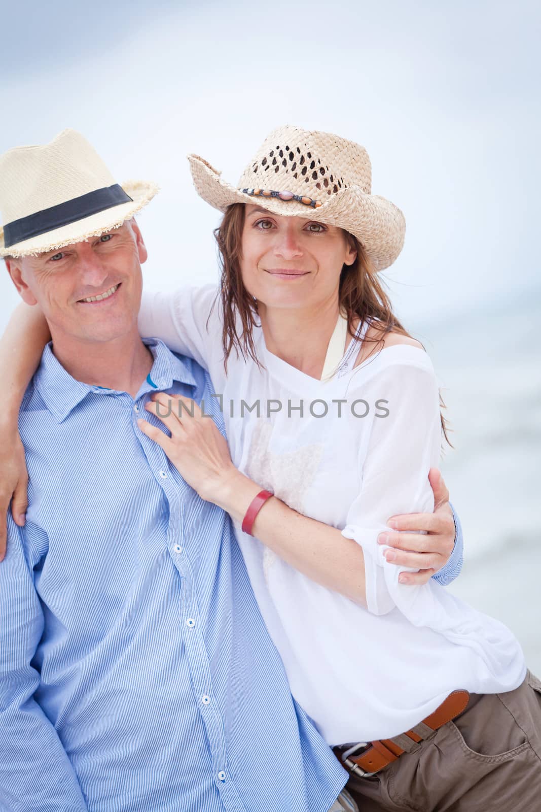 happy adult couple in summertime on beach having fun vacation